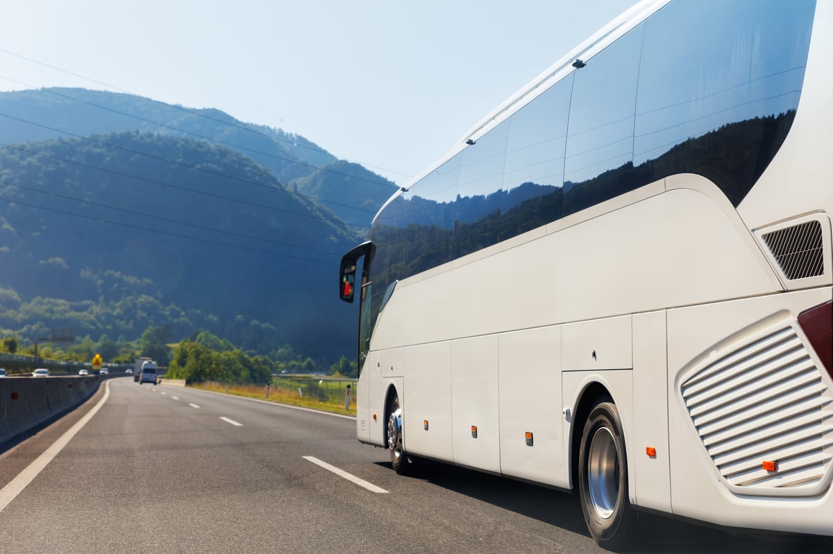 Modern luxury coach bus driving on a scenic highway